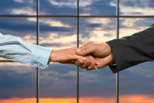 businessman-shakes-young-lady-s-hand-woman-s-handshake-sunrise-background-protection-trust-our-new-ally